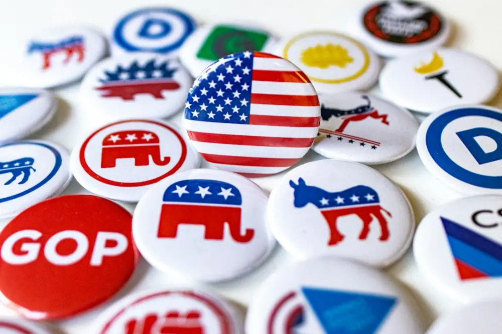 A pile of political buttons sitting on top of a table, illustrating grassroots political journalism